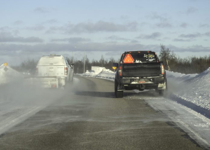 En långsamt körande epa-traktor blir omkörd på en väg utanför Kiruna