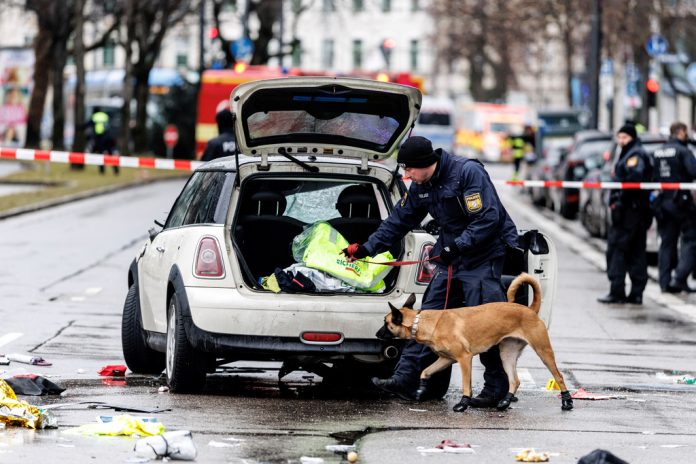 Polis och ambulanspersonal arbetar på den plats i München där en bil körts in i en demonstrerande folkmassa