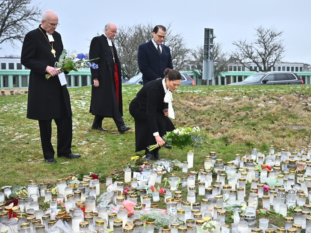 Ärkebiskopen Martin Modéus, biskop Johan Dalman, kronprinsessan Victoria och Prins Daniel lämnar blommor vid minnesplatsen utanför Risbergska skolan