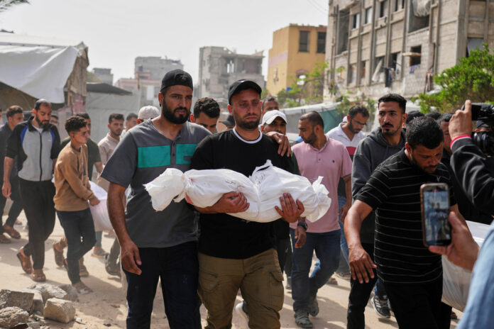 Saleh Zenati bär sitt döda syskonbarn Khalid Zenati, som dödats i en israelisk flygattack i södra Gazaremsan på söndagen